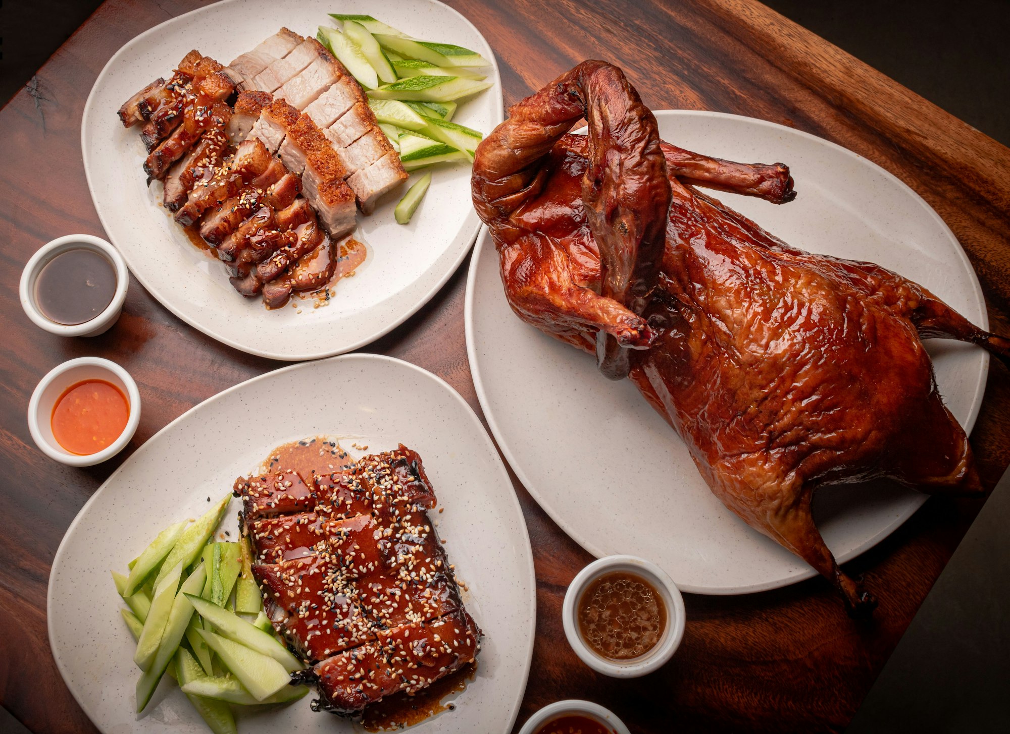 Peking duck and roasted pork served with sauces and fresh cucumbers